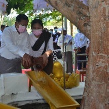 State Administration Council Chairman Commander-in-Chief of Defence Services Senior General Min Aung Hlaing, wife Daw Kyu Kyu Hla, Council members and wives pour water at banyan tree on fullmoon day of Kason